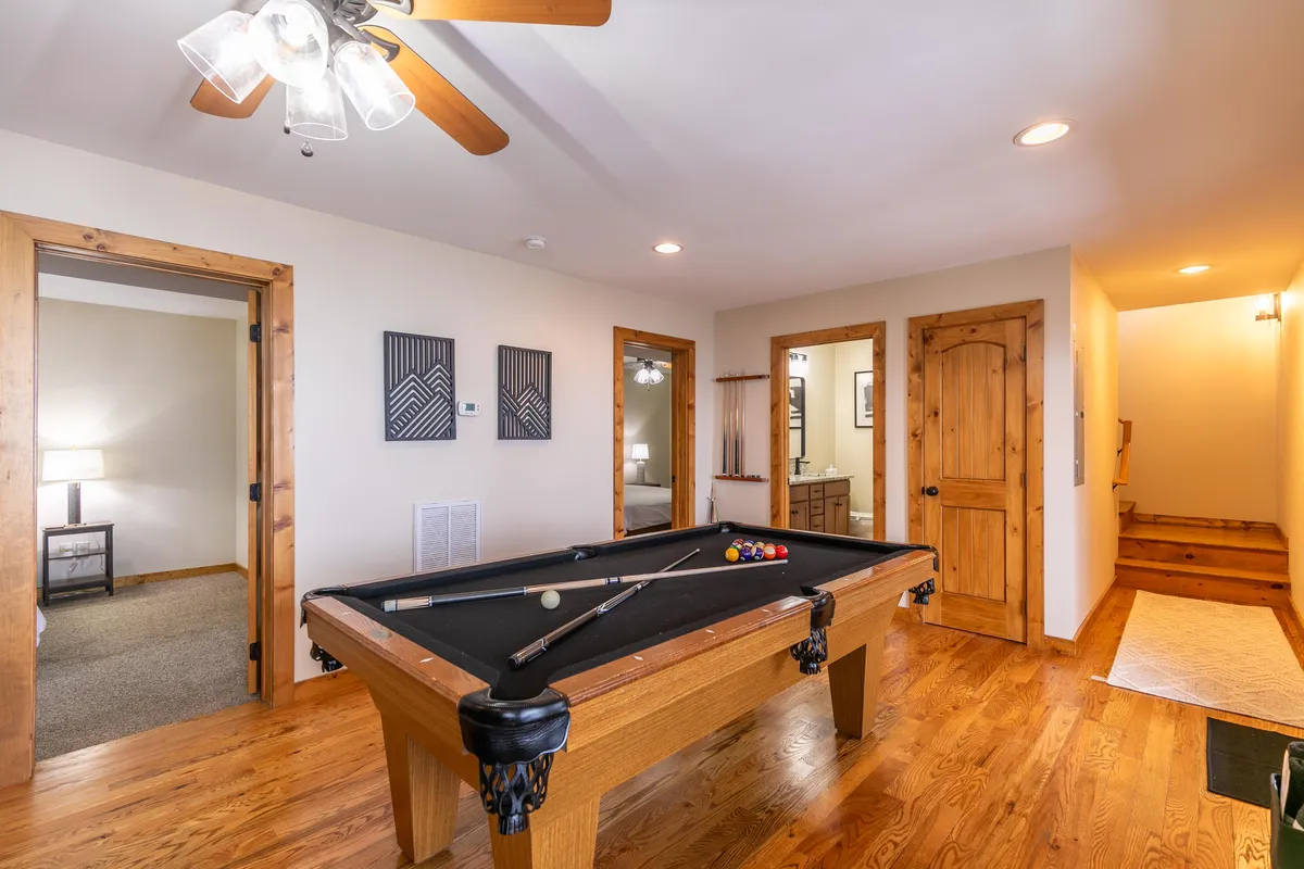 An inviting interior game room centered around a pool table, with cozy decor and plenty of space for family tournaments and friendly gatherings after a day outside.