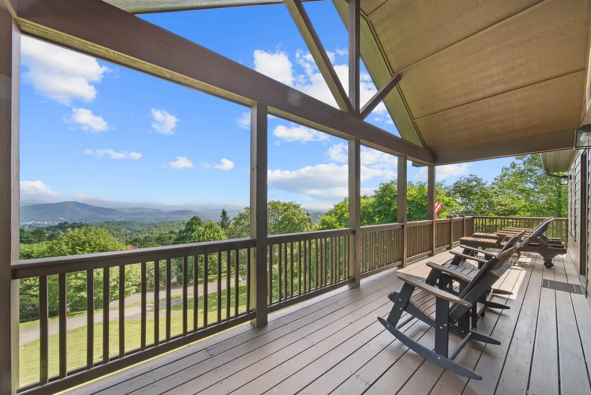 A tranquil porch scene with classic wooden rocking chairs facing a spectacular mountain vista. The scene is peaceful, with soft natural light illuminating the porch and the view beyond, suggesting an ideal spot for relaxation or watching the sunrise after an early morning hike.